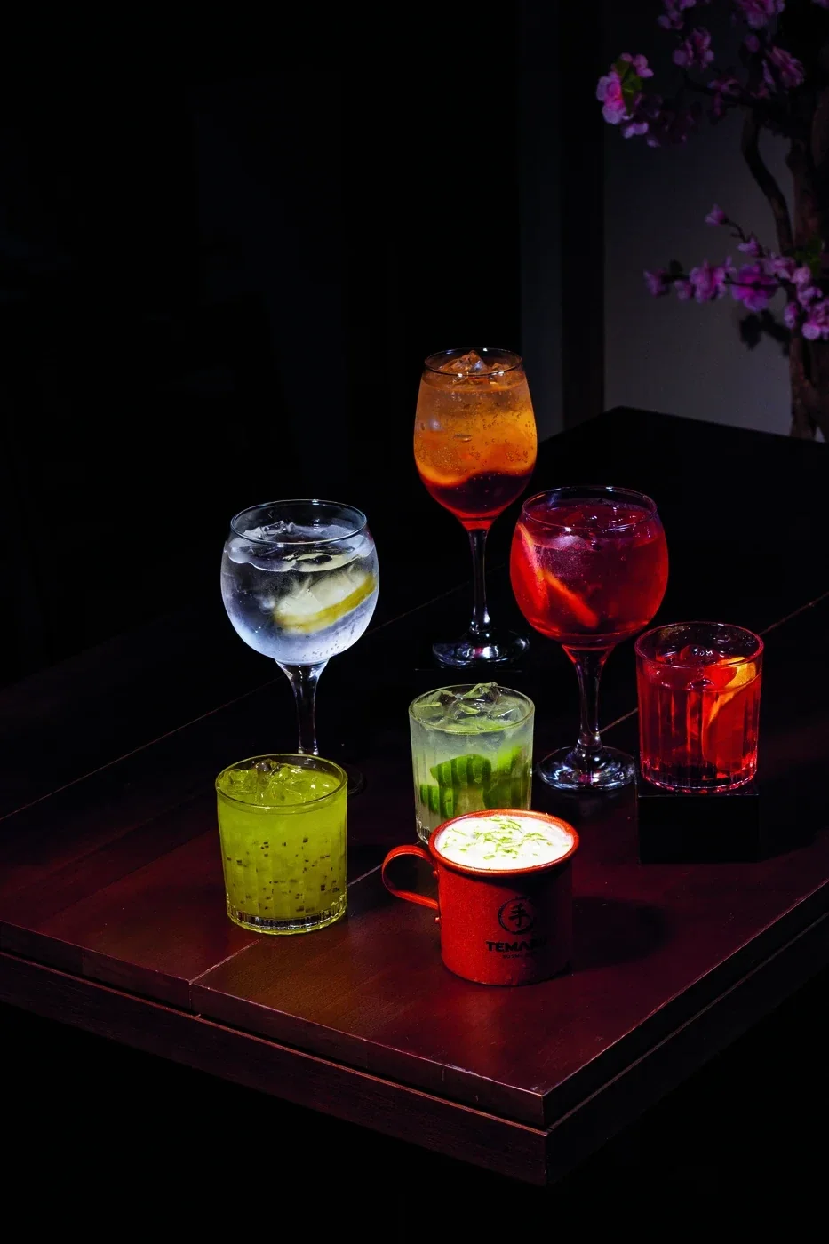 Os sete drinks da casa reunidos sobre a mesa de madeira do Temaru
